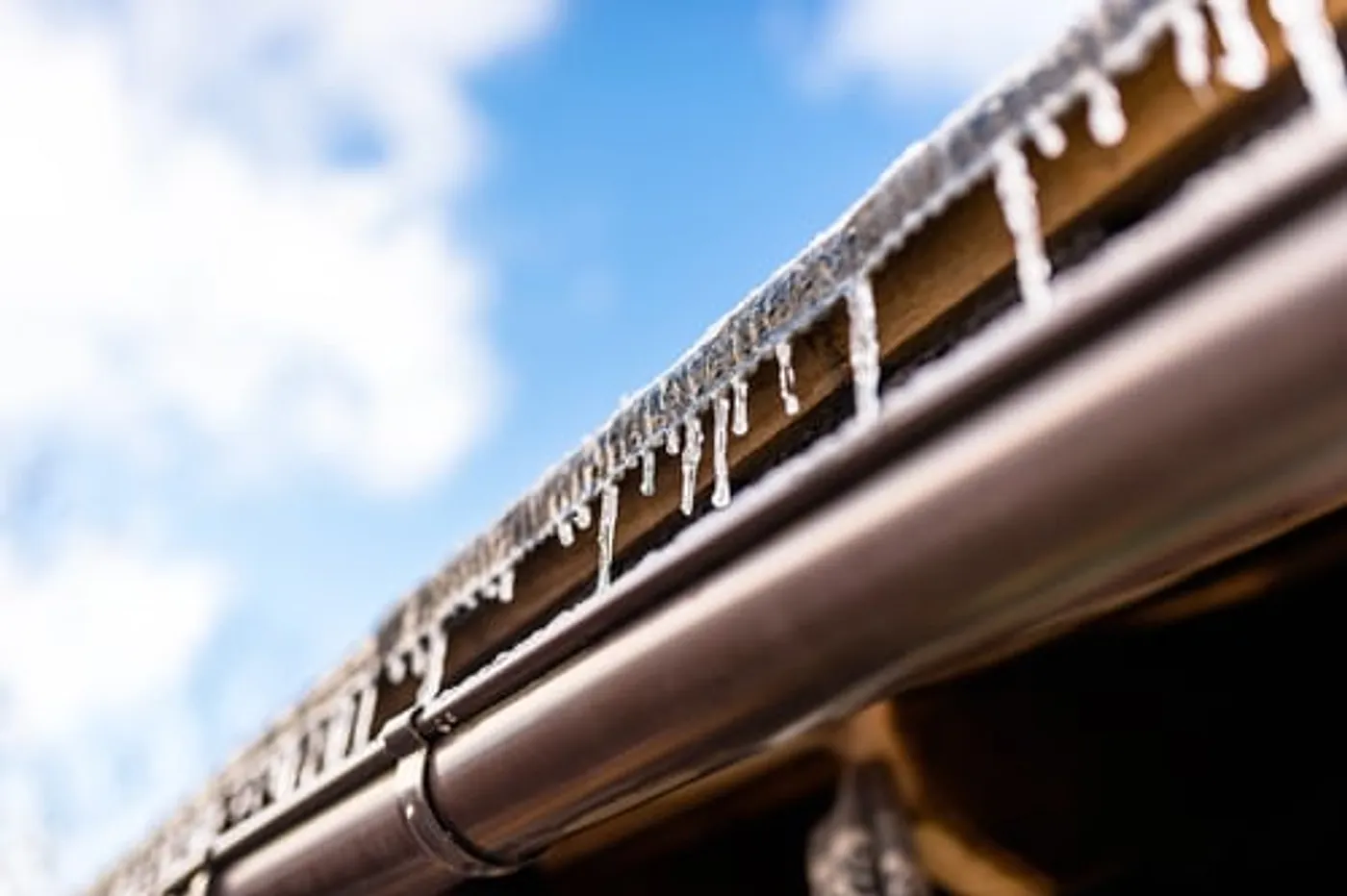 Icicles hanging from a home gutter after a winter freeze