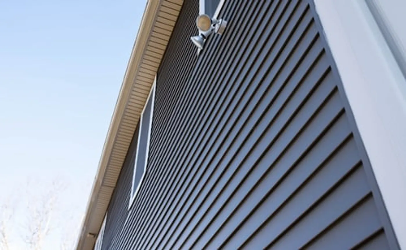 Crisp modern lap siding on the gable end of a house against a clear sky